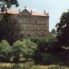 Chyše - zámek | jihozápadní křídlo zámku při pohledu z parku v roce 1991