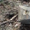Lučiny - železný kříž | rozlomená hlavice podstavce železného kříže v lese nad Lučinami - duben 2022