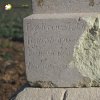 Kobylé - Forsterův kříž | poškozená část patky podstavce Forsterova kříže s částí německého nápisu - březen 2016
