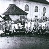 Jelení - kostel sv. Antonína Paduánského | děti s učitelem na školní zahradě za kostelem na historickém snímku z době před rokem 1945